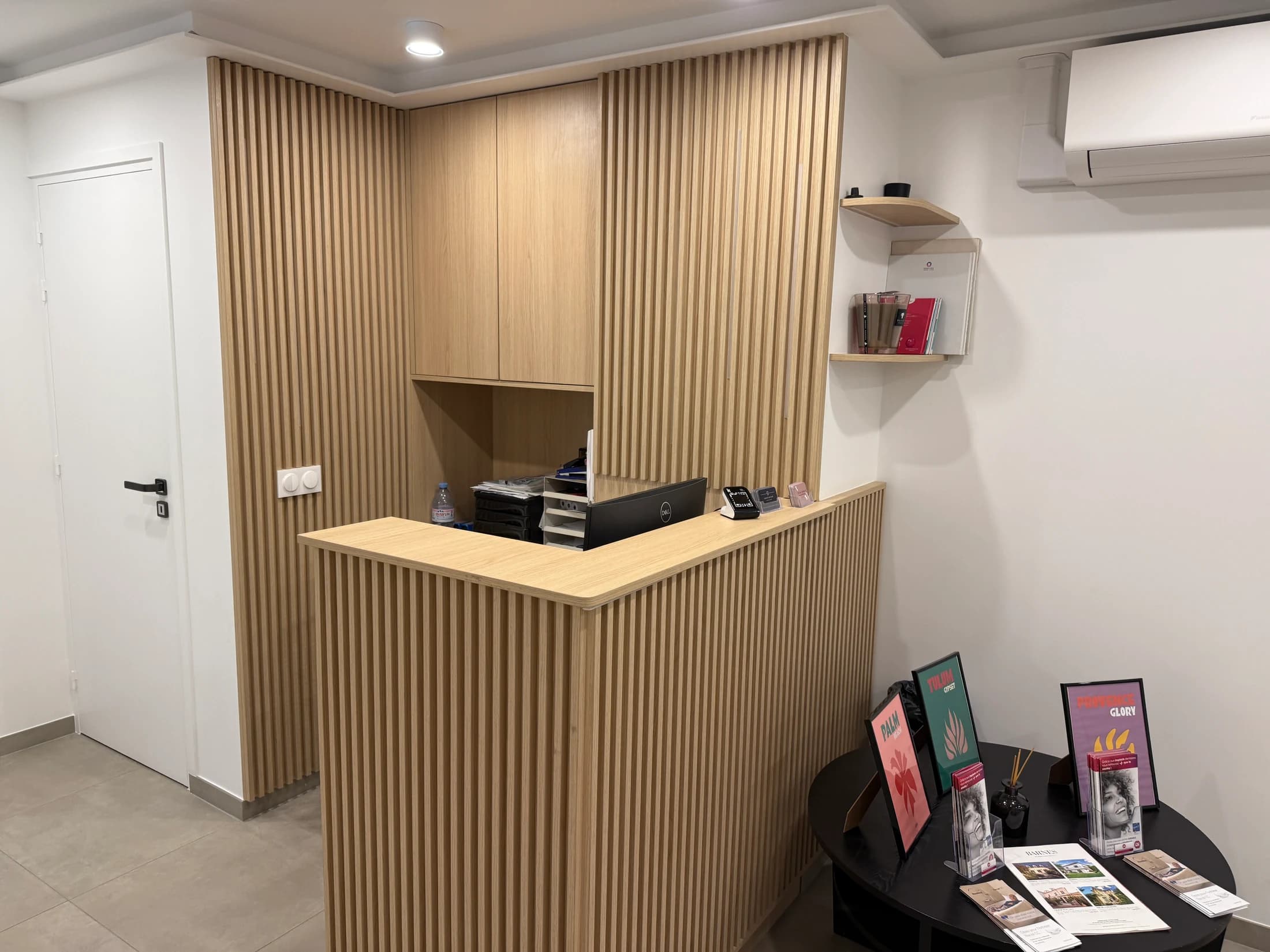Petit comptoir d’accueil en bois cannelé avec habillage mural assorti